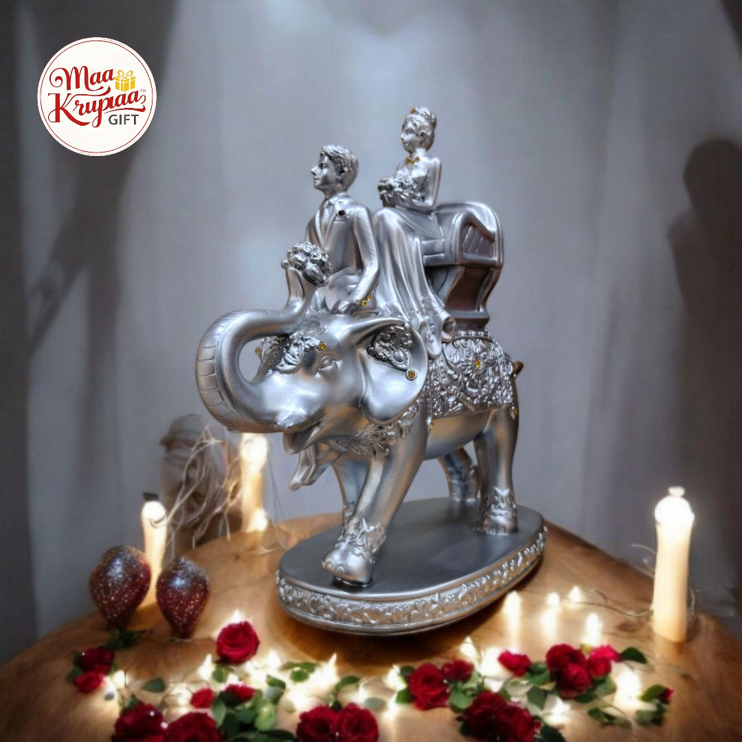 SILVER COLOURE COUPLE SITTING ON ELEPHANT L47
