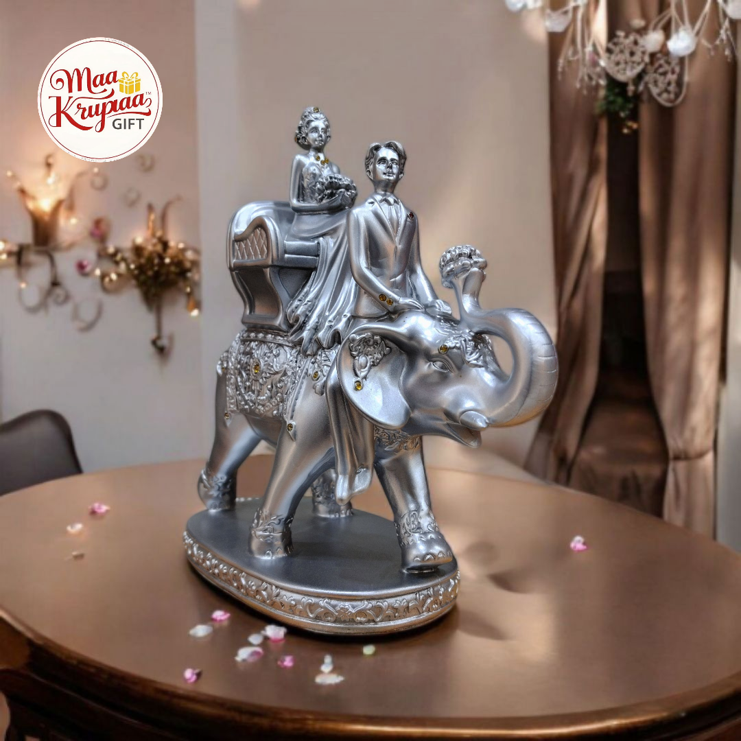 SILVER COLOURE COUPLE SITTING ON ELEPHANT L47